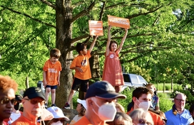 Image of crowd wearing orange shirts and three children holding signs about gun violence awareness