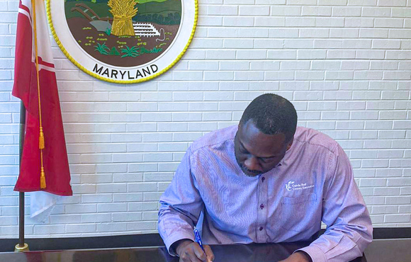 Calvin Ball signing executive order with Howard County Seal in background