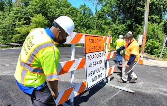 Image of Calvin Ball removing a road closed sign