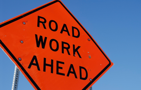 Image of a road work ahead orange sign