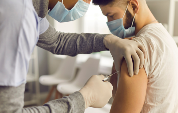 Image of doctor administering vaccine to man