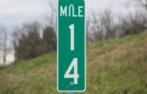 Image of green sign that reads mile marker 14