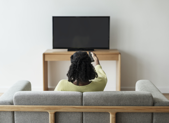 woman turning on a tv