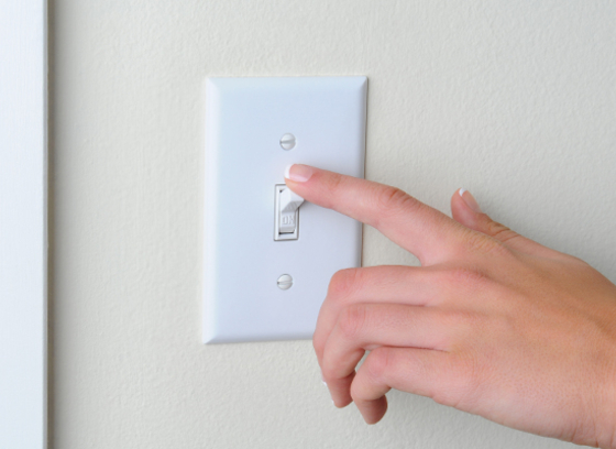 woman flipping a light switch