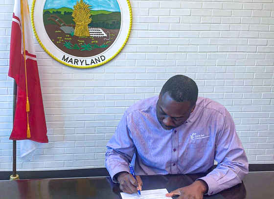 Calvin Ball signing executive order with Howard County Seal in background