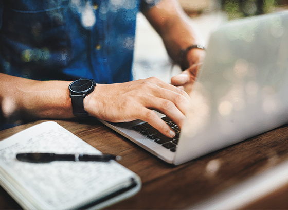 Masculine-leaning person searching for something on a laptop