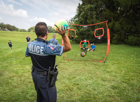 Officer throws football into net.