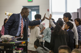 Calvin Ball giving student a high five in a classroom