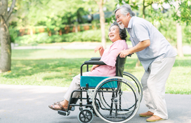 man pushing woman in wheelchair