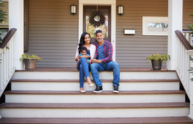 woman, man, and child sitting on porch steps