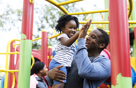man and child high-fiving at a playground