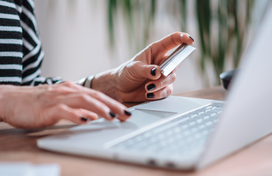 woman holding credit card and using the computer