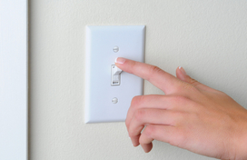 woman flipping a light switch