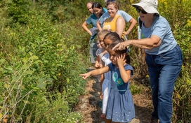 adults and children walking down a trail