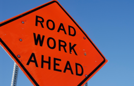 Image of a road work ahead orange sign